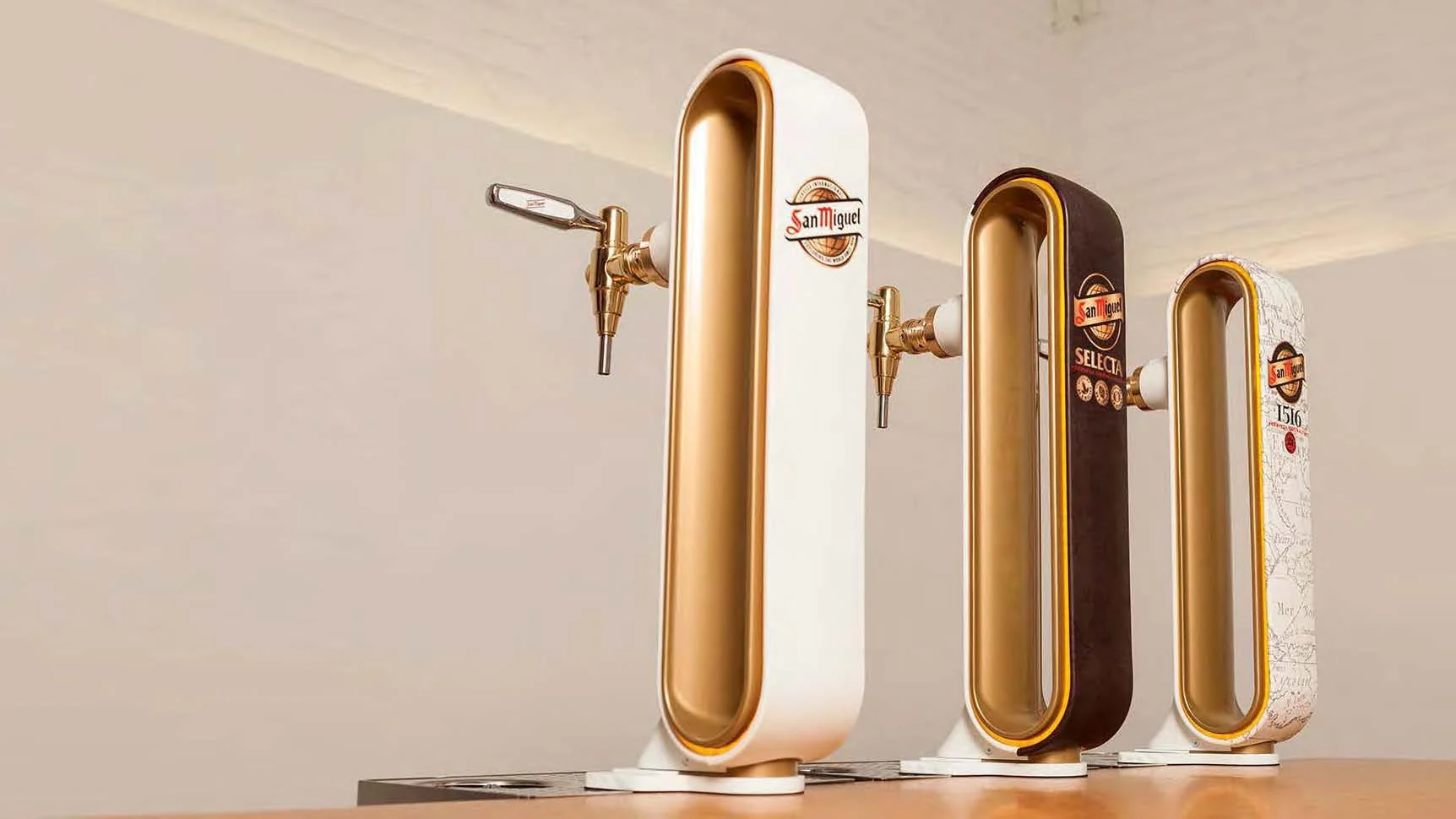 Tres columnas de cerveza San Miguel Especial diseñadas por Innou, con acabado dorado